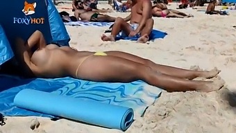 Sunbathing Topless On The Beach To Be Watched By Other Men
